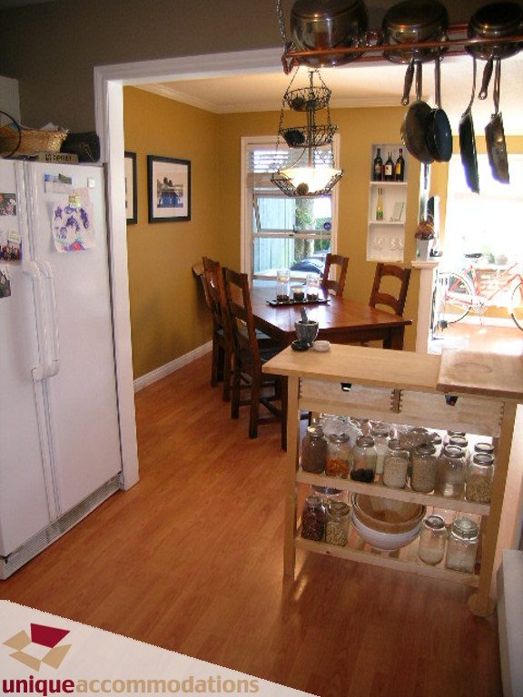 Bright kitchen with wooden floors, open shelving, and hanging pots, perfect for a cozy home. - 50 - 900 West 17th, North Vancouver