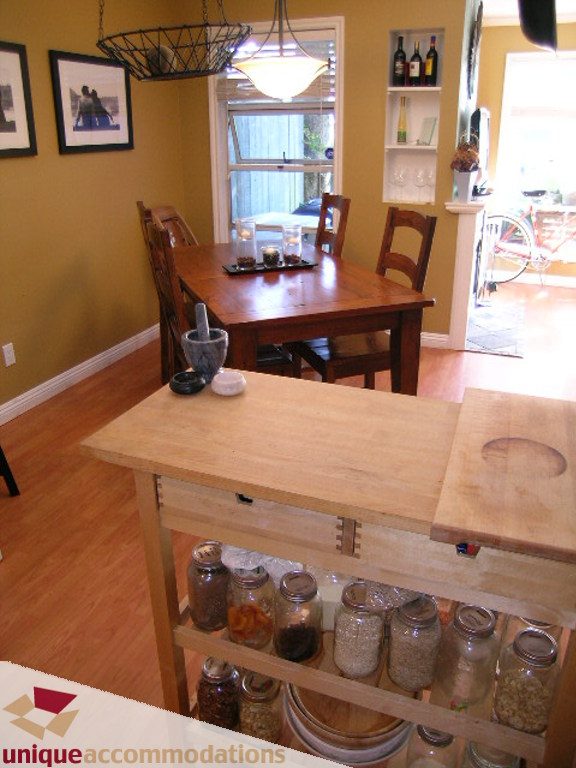 Bright dining area with wooden table, shelves, and hardwood floors. - 50 - 900 West 17th, North Vancouver