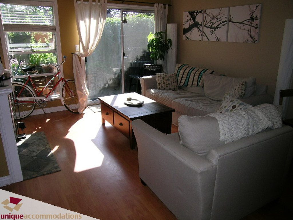 Bright living room with hardwood floors, a cozy sofa, and a bicycle in the corner. - 50 - 900 West 17th, North Vancouver