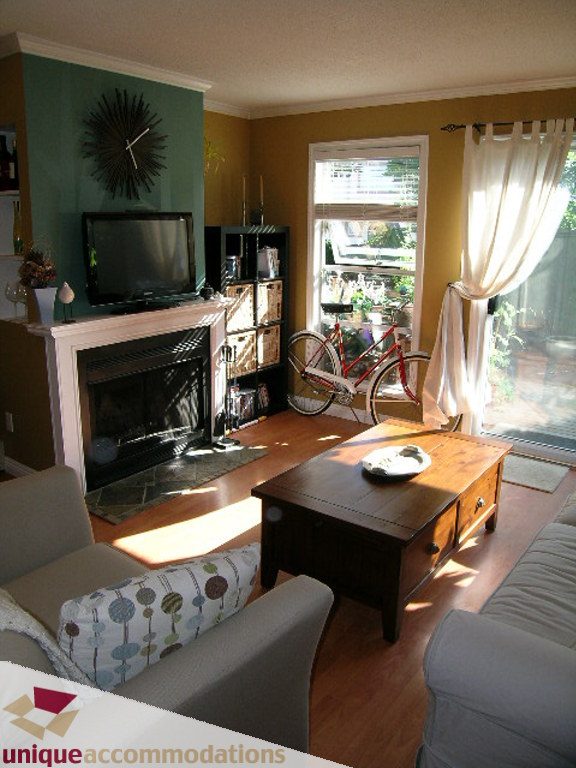 Furnished living room with hardwood floors, a fireplace, and a bicycle leaning against the wall. - 50 - 900 West 17th, North Vancouver