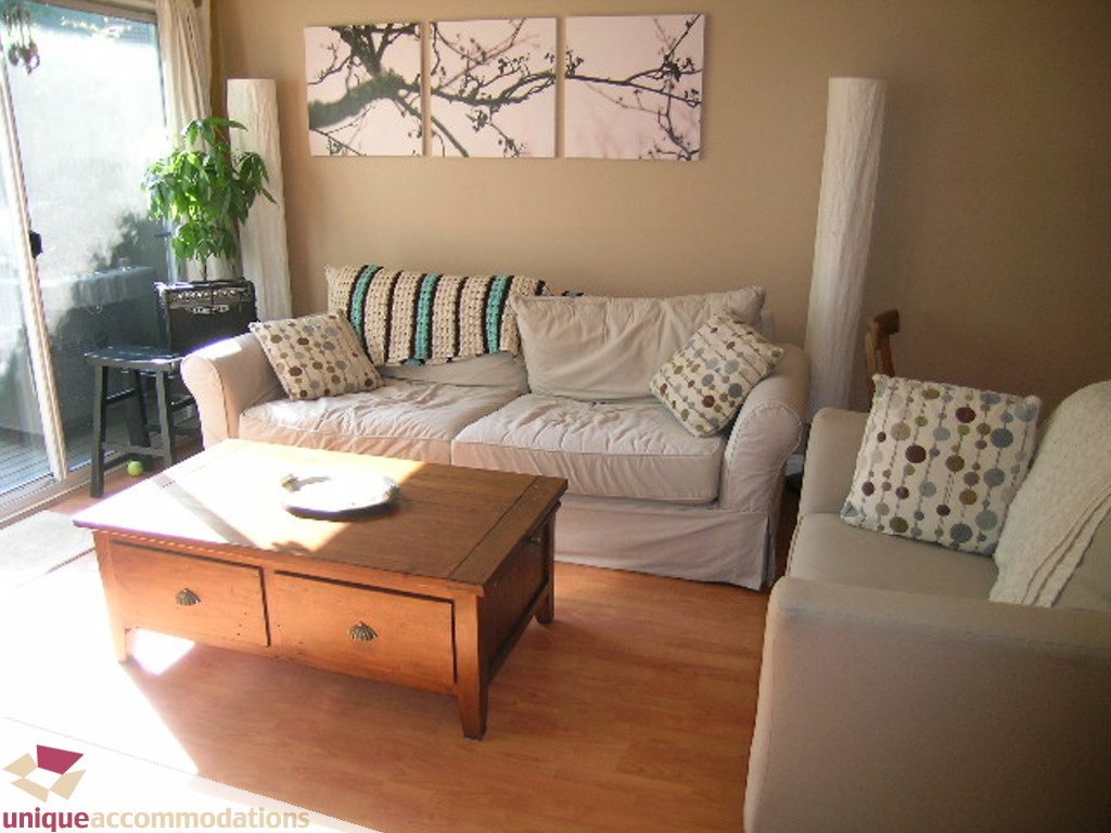 Furnished living room with hardwood floors, a wooden coffee table, and a cozy sofa set. - 50 - 900 West 17th, North Vancouver