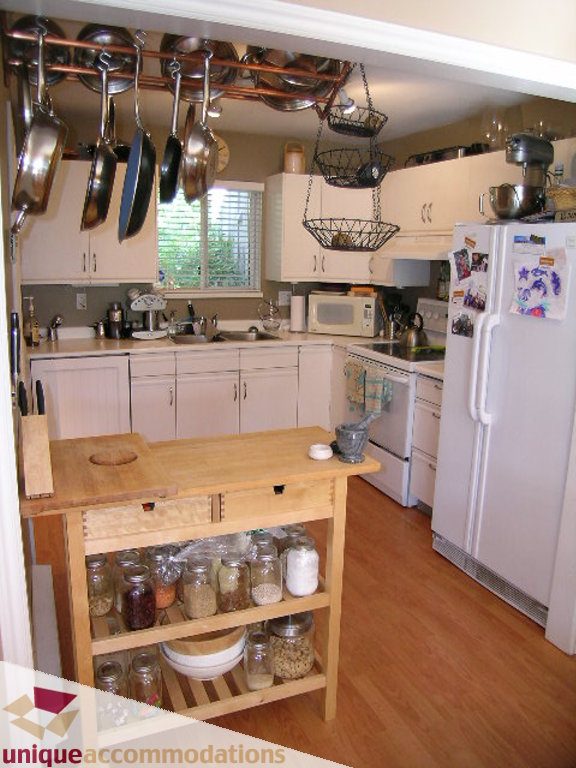 Bright kitchen with wooden island, hardwood floors, and hanging pots and pans. - 50 - 900 West 17th, North Vancouver