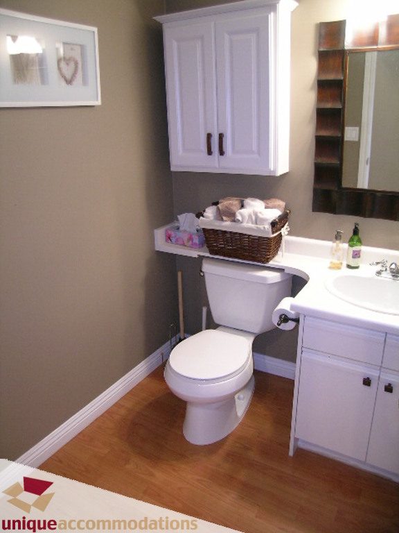 Bright bathroom with white cabinets, hardwood floors, and a sink with a mirror. - 50 - 900 West 17th, North Vancouver