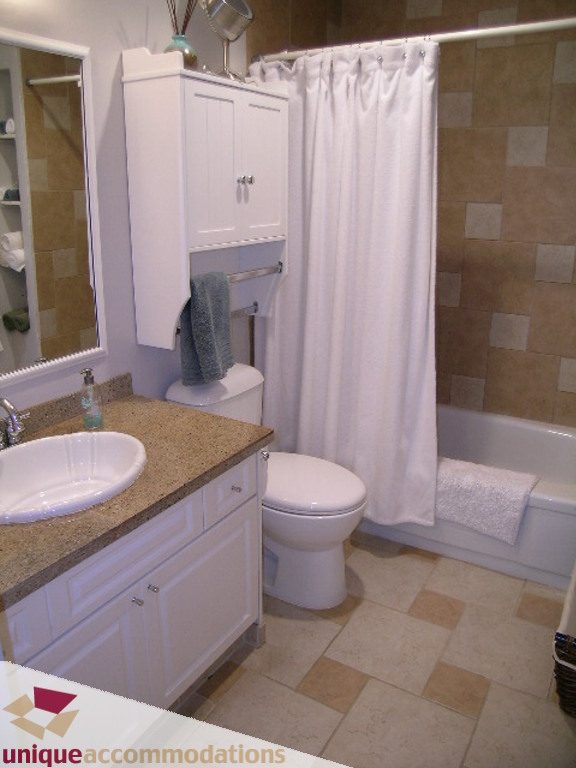 Bathroom with granite countertop, white cabinets, and tiled floor. - 50 - 900 West 17th, North Vancouver