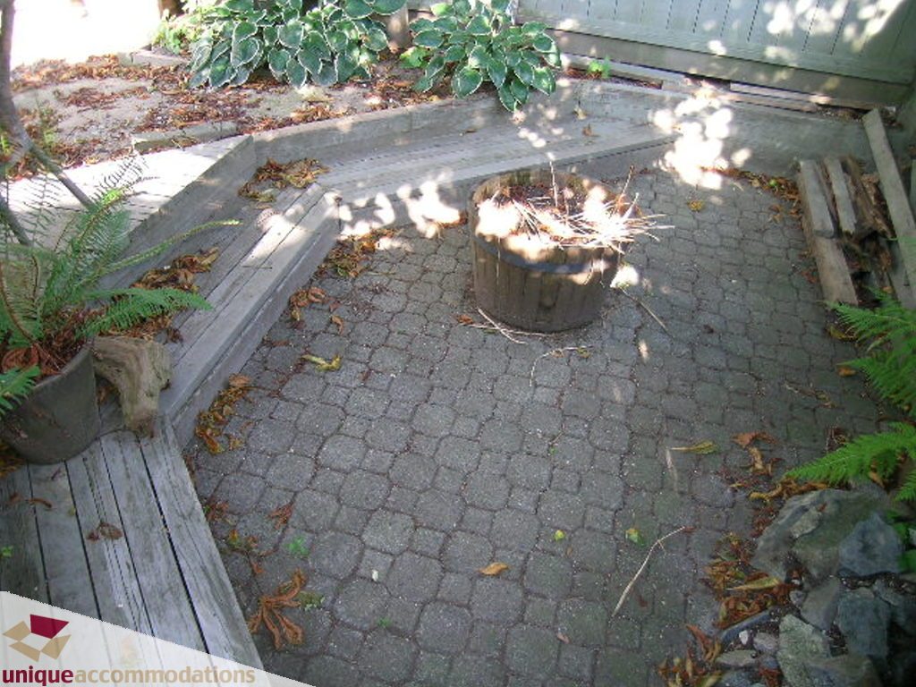 Furnished patio with paver stones, wooden deck, and hosta plants. - 50 - 900 West 17th, North Vancouver