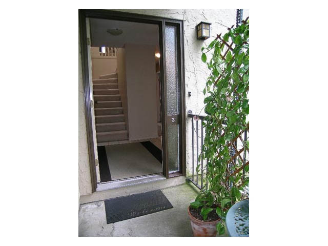 Framed entryway with a view of the interior staircase and a potted plant. - 3-220 East 4th Street, North Vancouver