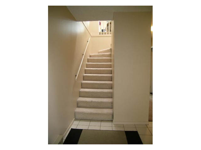 Staircase leading to upper level with carpeted steps and tiled landing. - 3-220 East 4th Street, North Vancouver