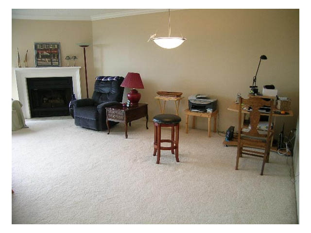 Living room with beige walls, carpeted floor, and a fireplace. - 3-220 East 4th Street, North Vancouver