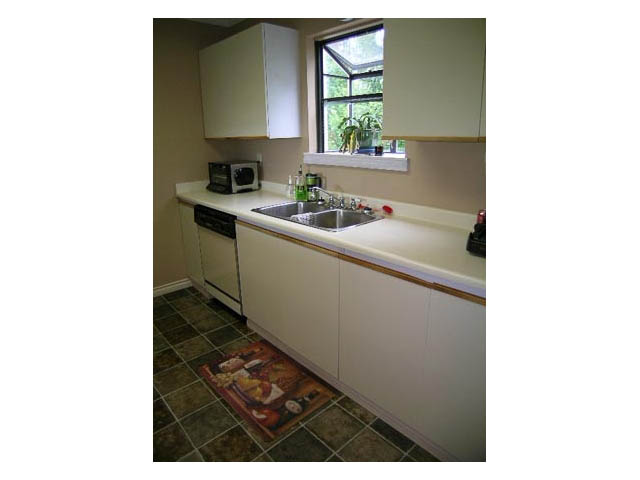 Bright kitchen with white cabinets, granite countertops, and a window view. - 3-220 East 4th Street, North Vancouver