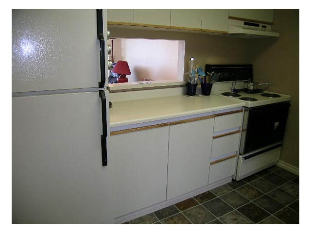 Bright kitchen with white cabinets and a white stove, clean and ready for move-in. - 3-220 East 4th Street, North Vancouver