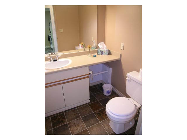 Bathroom with white vanity, tiled floor, and tissue box on countertop. - 3-220 East 4th Street, North Vancouver
