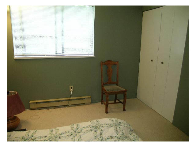 Bright bedroom with a bed, chair, and closet, carpeted floor. - 3-220 East 4th Street, North Vancouver
