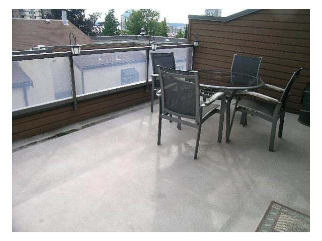 Furnished patio with glass table and chairs, city view in background. - 3-220 East 4th Street, North Vancouver