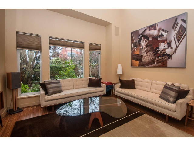 Furnished living room with large windows, hardwood floors, and a modern art piece on the wall. - 1882 Whyte Avenue, Vancouver West Side