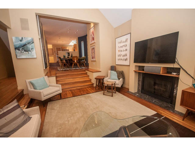 Spacious living room with hardwood floors, modern furniture, and a large flat-screen TV. - 1882 Whyte Avenue, Vancouver West Side