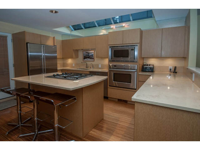 Bright kitchen with modern stainless steel appliances, granite countertops, and hardwood floors. - 1882 Whyte Avenue, Vancouver West Side