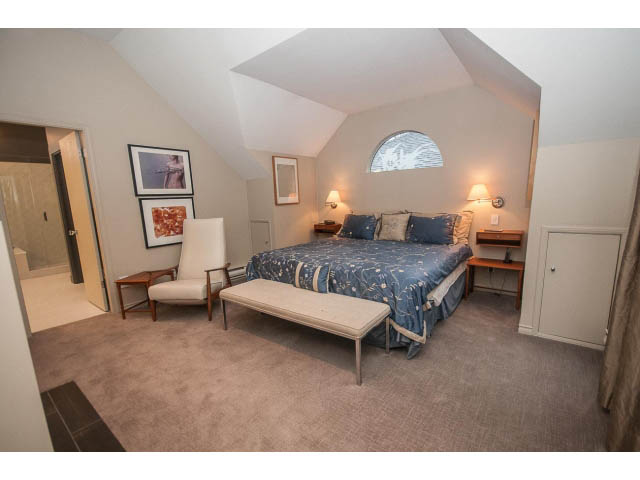 Furnished bedroom with a cozy bed, desk, and chair, featuring a window with a view. - 1882 Whyte Avenue, Vancouver West Side
