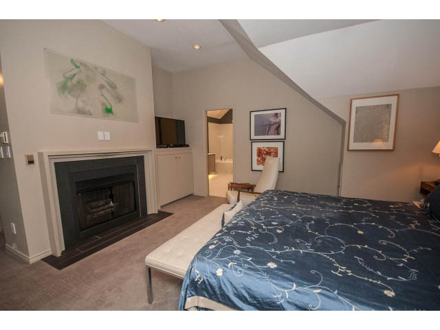 Spacious bedroom with a cozy fireplace and a comfortable bed. - 1882 Whyte Avenue, Vancouver West Side
