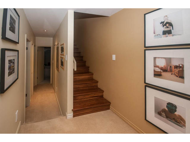 Staircase leading to upper level with framed artwork on walls. - 1882 Whyte Avenue, Vancouver West Side