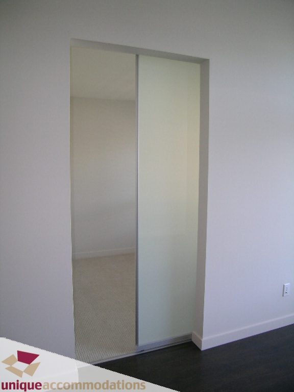 Furnished bedroom with sliding glass doors leading to a balcony. - 510 - 1677 Lloyd Avenue, North Vancouver