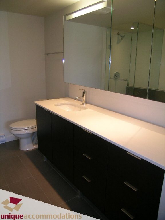Modern bathroom with sleek black cabinets and white countertop. - 510 - 1677 Lloyd Avenue, North Vancouver