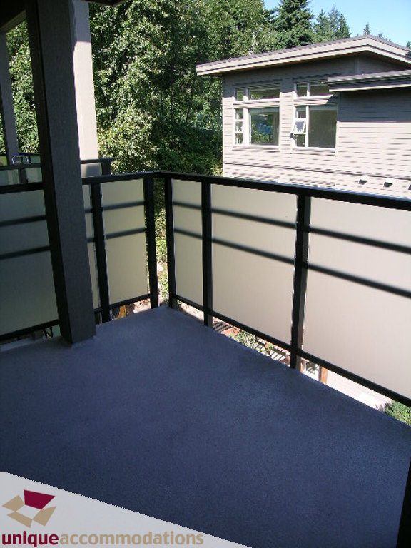 Balcony with modern railing and view of trees. - 510 - 1677 Lloyd Avenue, North Vancouver