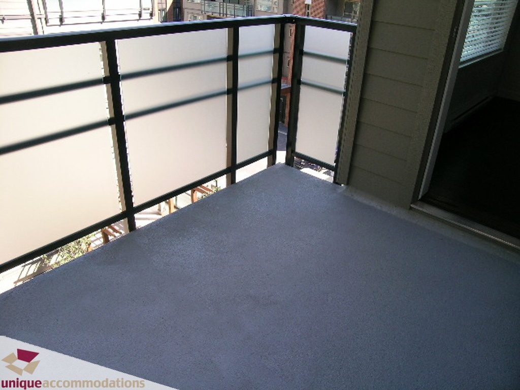 Furnished bedroom with a balcony and city view. - 510 - 1677 Lloyd Avenue, North Vancouver