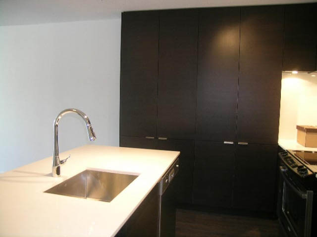 Bright kitchen with white countertops, dark cabinets, and modern sink. - 302 - 1677 Lloyd Avenue, North Vancouver