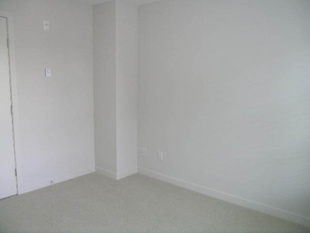 Empty bedroom with plain walls and carpeted floor. - 302 - 1677 Lloyd Avenue, North Vancouver