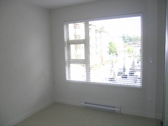 Bright living room with large window and city view. - 302 - 1677 Lloyd Avenue, North Vancouver