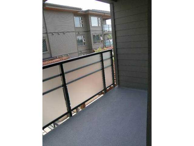 Furnished balcony with wooden railings and city view. - 302 - 1677 Lloyd Avenue, North Vancouver