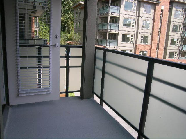 Furnished balcony with glass railing and city view. - 302 - 1677 Lloyd Avenue, North Vancouver