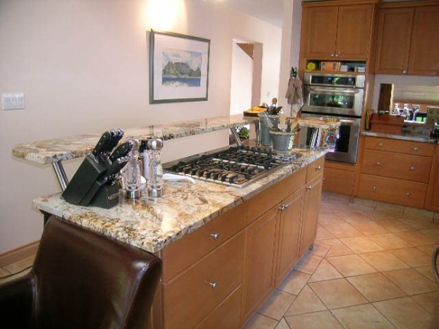 Bright kitchen with granite countertops, wooden cabinets, and a tiled floor. - 1077 Blue Grouse Way, North Vancouver