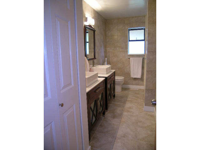 Spacious bathroom with beige tiles and a window. - 1077 Blue Grouse Way, North Vancouver