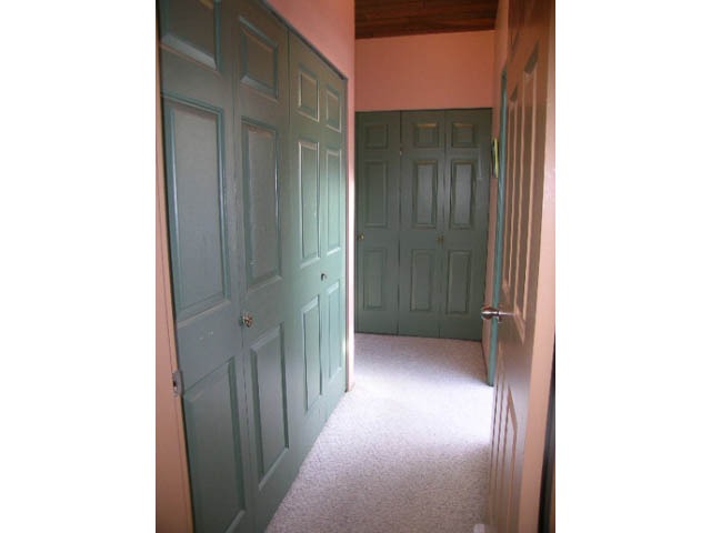 Bright hallway with carpeted floors and green doors leading to bedrooms. - 1077 Blue Grouse Way, North Vancouver