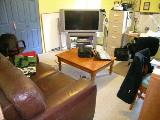 Living room with leather couch, wooden coffee table, and TV setup. - 1077 Blue Grouse Way, North Vancouver