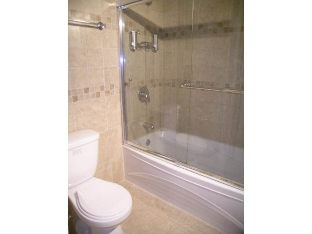 Bathroom with walk-in shower and toilet, neutral tile walls. - 1077 Blue Grouse Way, North Vancouver