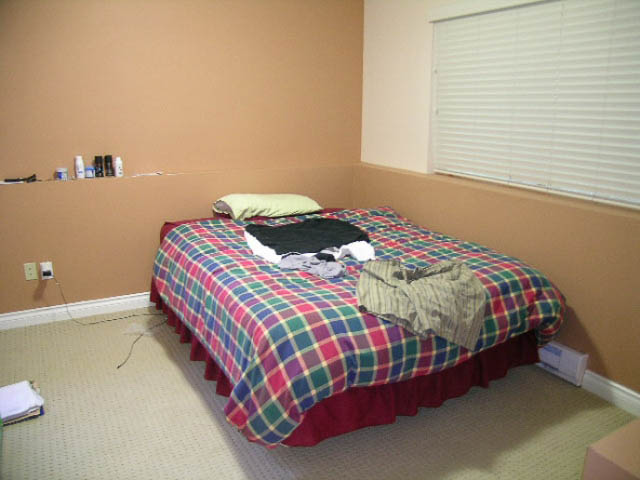 Small bedroom with plaid bedding and a window with blinds. - 1077 Blue Grouse Way, North Vancouver
