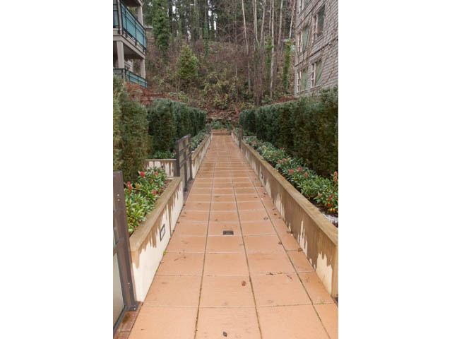 Furnished living room with cozy corner, large windows, and outdoor access. - 215 - 1677 Lloyd Avenue, North Vancouver