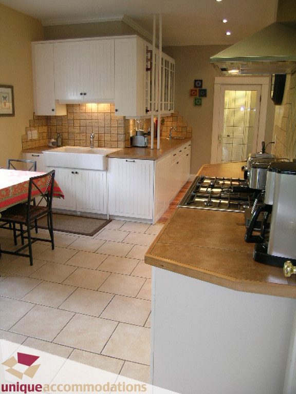 Bright kitchen with white cabinets, tiled backsplash, and a gas stove. - 813 - 5th Street East, North Vancouver