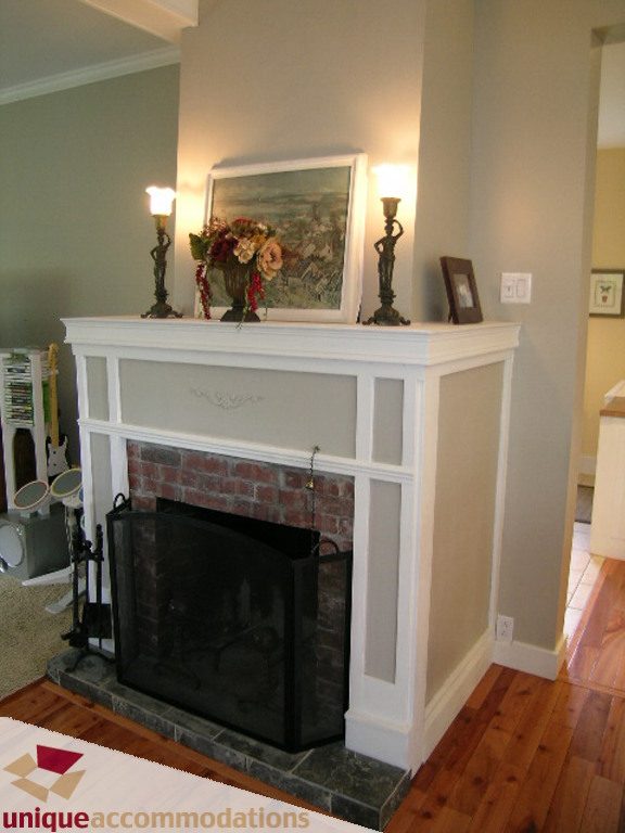 Living room with hardwood floors and a cozy fireplace with a mantel. - 813 - 5th Street East, North Vancouver
