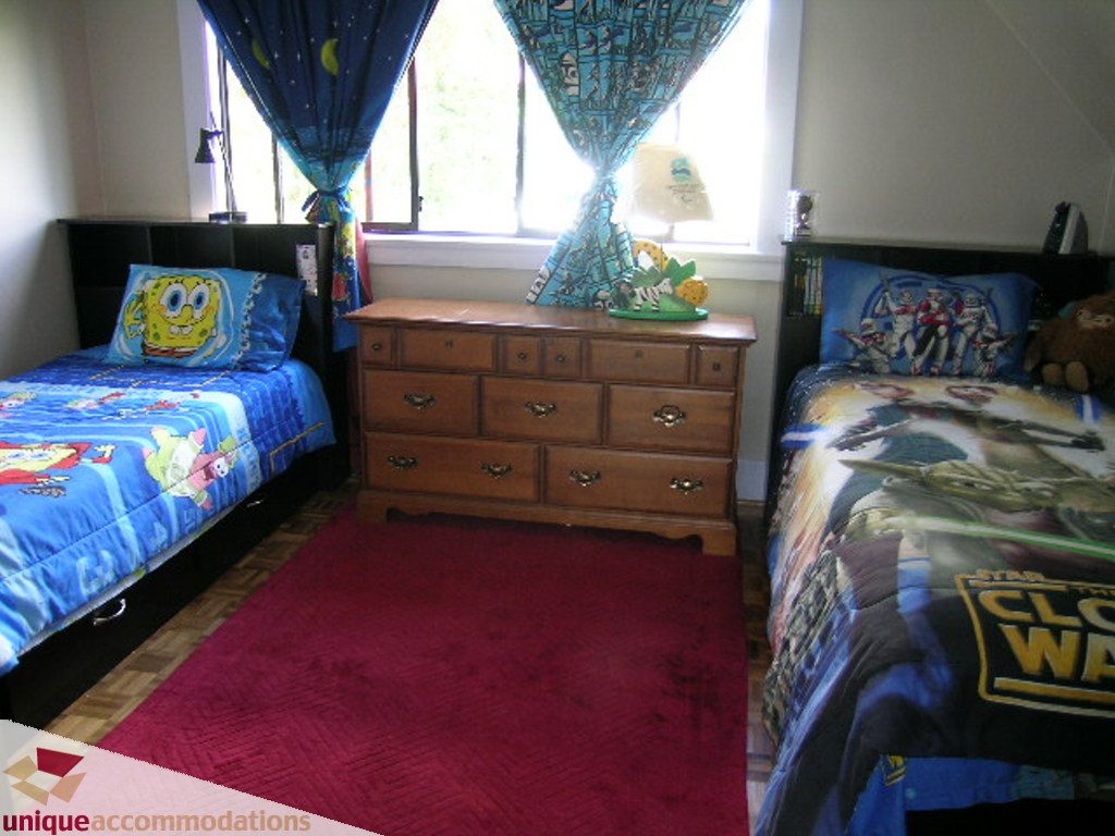 Bright bedroom with SpongeBob and Star Wars-themed bedding, wooden dresser, and red carpet. - 813 - 5th Street East, North Vancouver