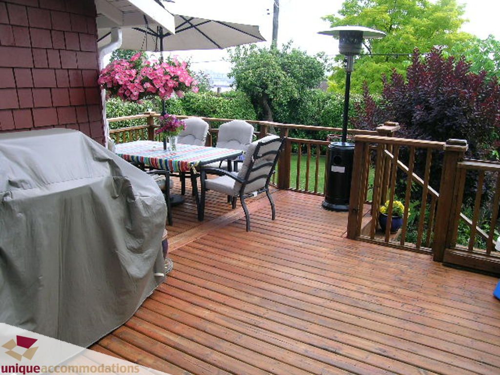 Furnished patio with wooden deck, outdoor furniture, and garden view. - 813 - 5th Street East, North Vancouver
