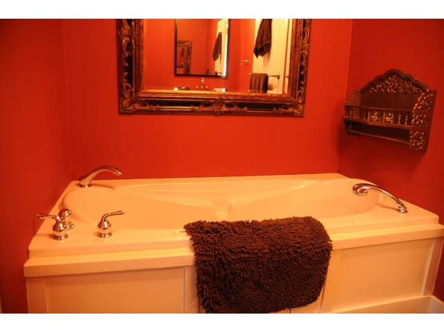 Shared bathroom with red walls, white countertop, and ornate mirror. - 3998 West 10th Avenue, Vancouver West Side