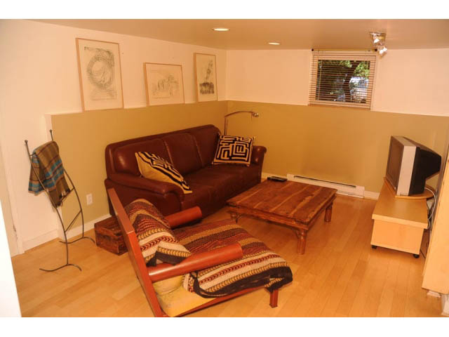 Furnished living room with hardwood floors, leather couch, and wooden coffee table. - 3998 West 10th Avenue, Vancouver West Side