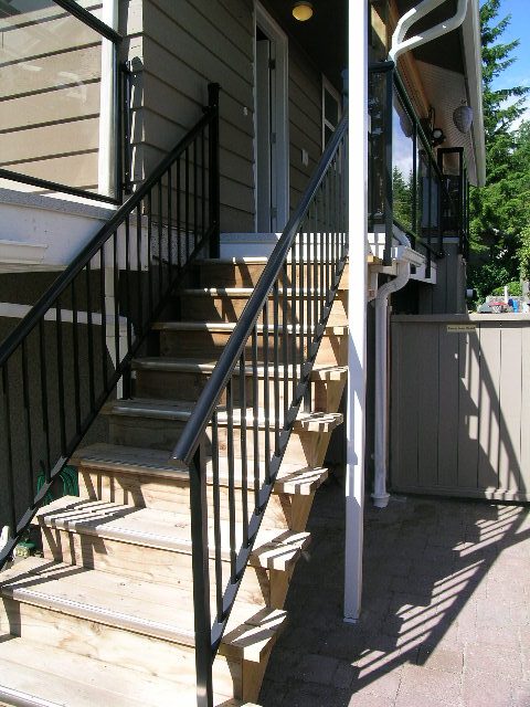 Furnished 2-bedroom + den with wooden stairs and black railings. - #2 (Upper) - 350 23rd St E, North Vancouver