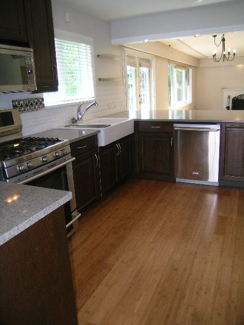 Bright kitchen with granite countertops, hardwood floors, and a view of the living area. - #2 (Upper) - 350 23rd St E, North Vancouver