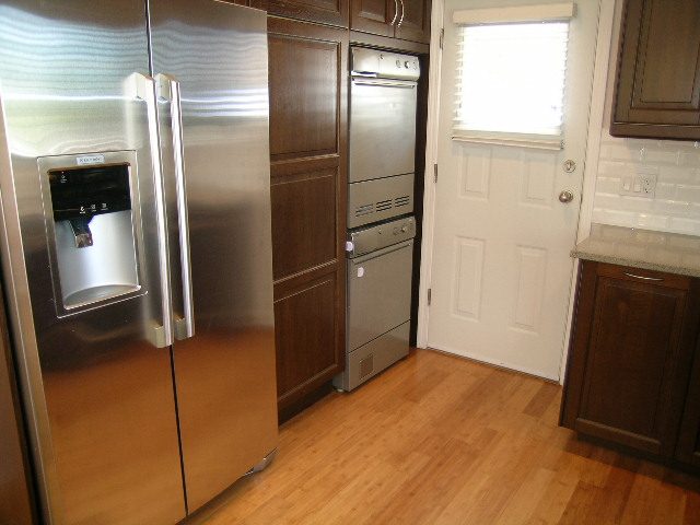 Bright kitchen with stainless steel appliances, hardwood floors, and a window. - #2 (Upper) - 350 23rd St E, North Vancouver