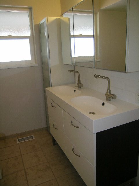 Bright bathroom with white sink, modern faucet, and mirrored cabinet. - #2 (Upper) - 350 23rd St E, North Vancouver