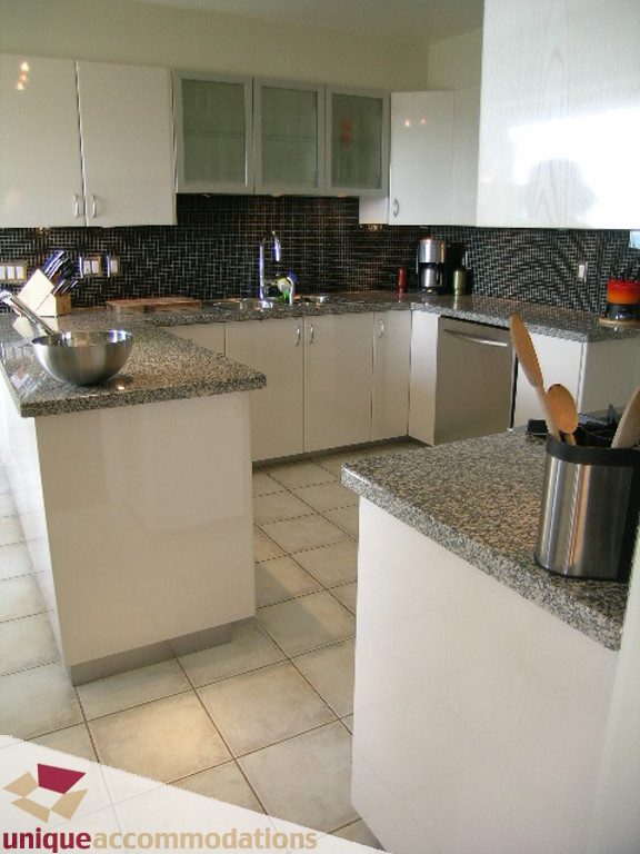 Bright kitchen with granite countertops and white cabinetry, modern tile backsplash. - 68 Bonnymuir Drive, West Vancouver